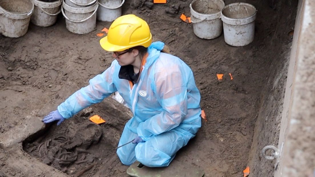 Haddewich Eggels is archeoloog en teamleider van dit bijzondere onderzoek. Ze wijst hier op de stenen sarcofaag waar het lichaam in ligt.