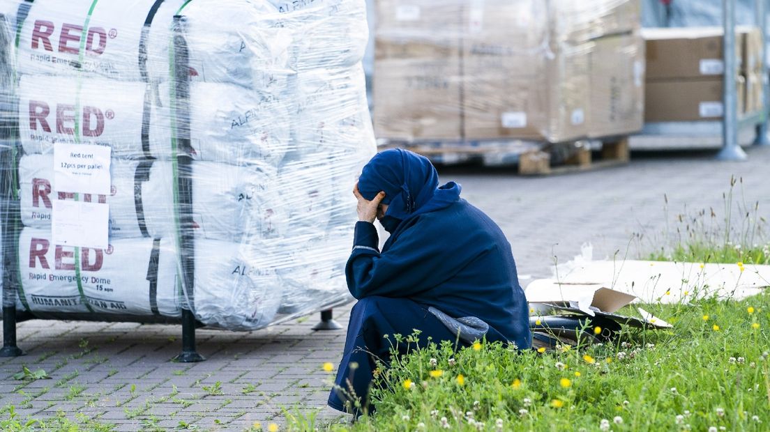 Een vluchteling wacht op de parkeerplaats van het aanmeldcentrum in Ter Apel