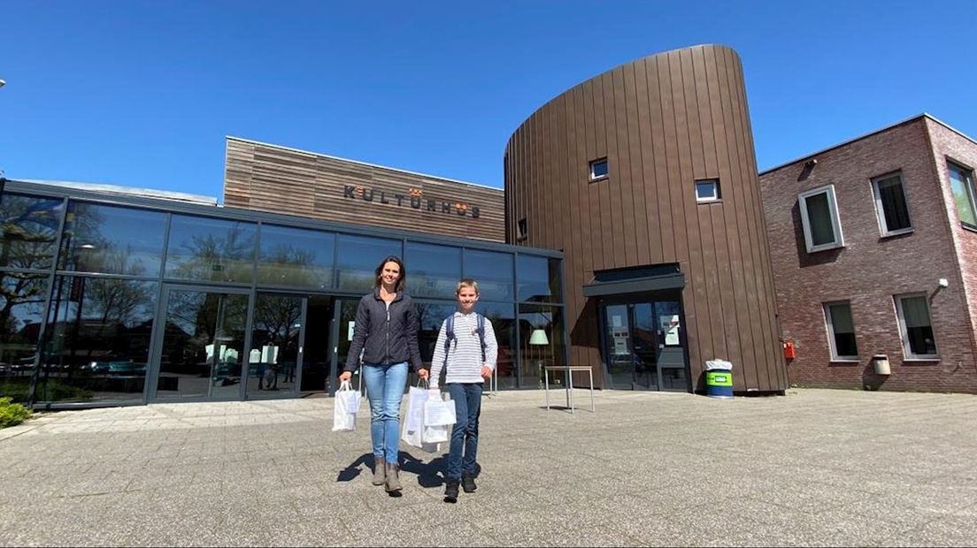 Henriëtte  Veenstra en zoon Stijn halen de boeken op bij de bibliotheek in Borne