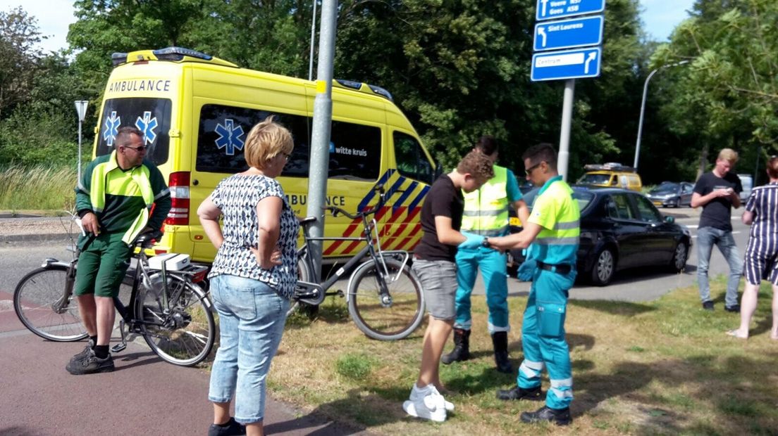 Fietser (15) wordt onderzocht door ambulancepersoneel na aanrijding met lijnbus