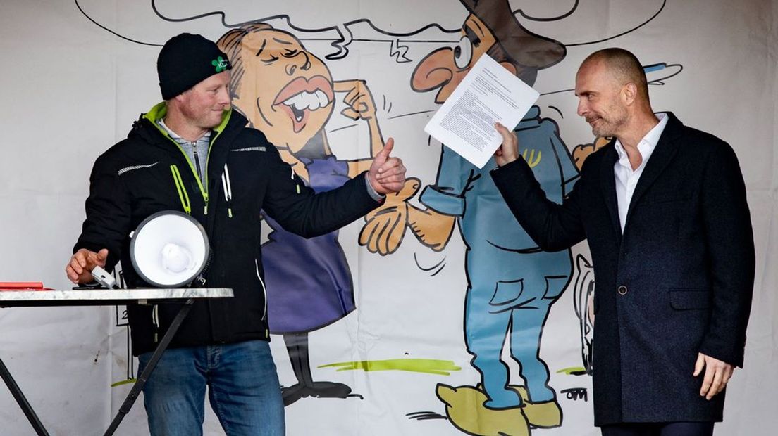 Schiphol-directeur Robert Carsouw neemt het 'koopcontract' in ontvangst.