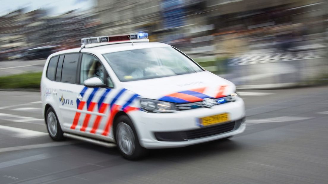 Hardrijdende politiewagen met loeiende sirenes en zwaailichten ANP-327056775