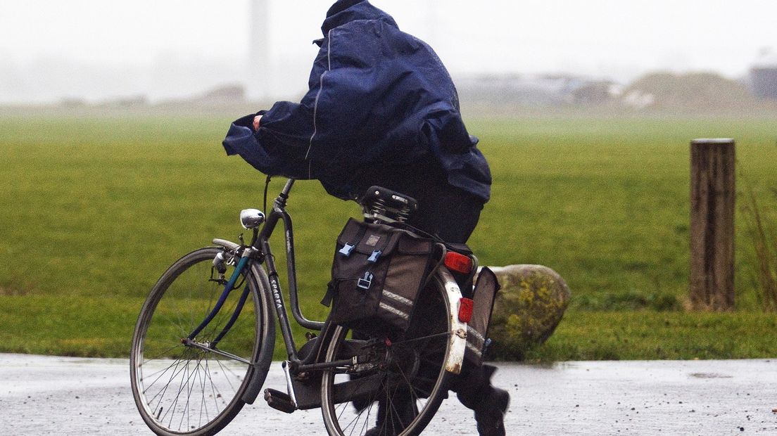 Een fietser baant zich een weg door de storm (archief)