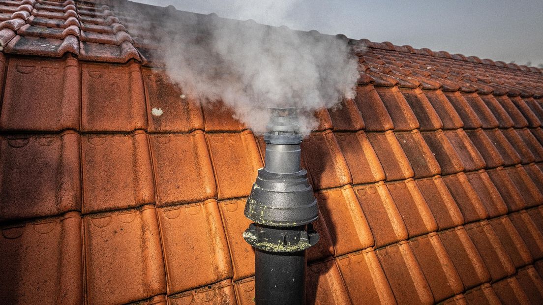 Rook van een verwarming komt uit de schoorsteen