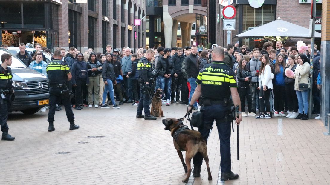 Politie met honden houdt toeschouwers op afstand