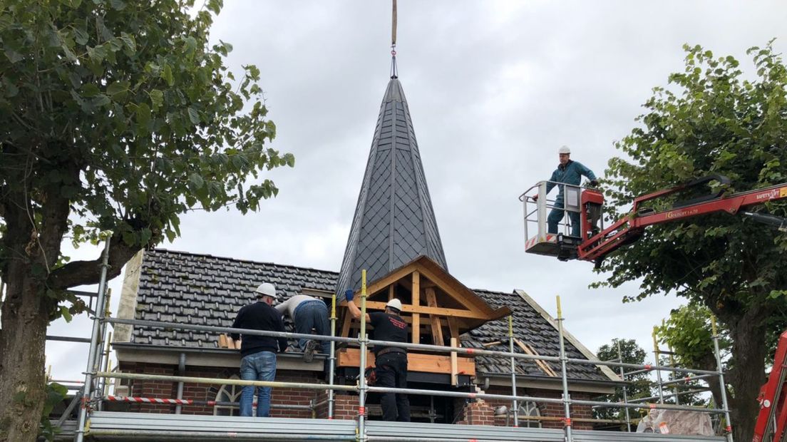 Bouwvakkers zijn bezig bij de torenspits