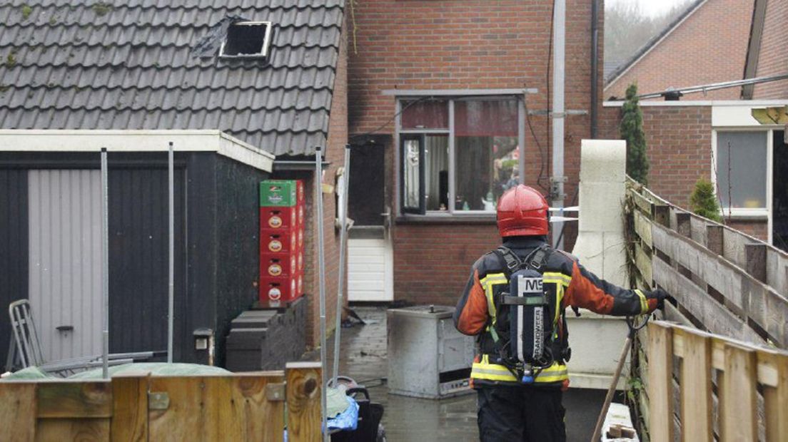 Een brandweerman blust de radiozender in de tuin van de woning.