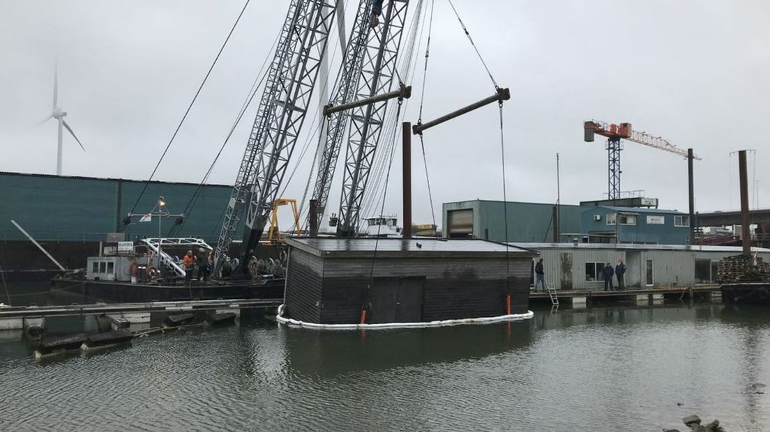 De loods wordt uit het water van de Nieuwe Haven getakeld.