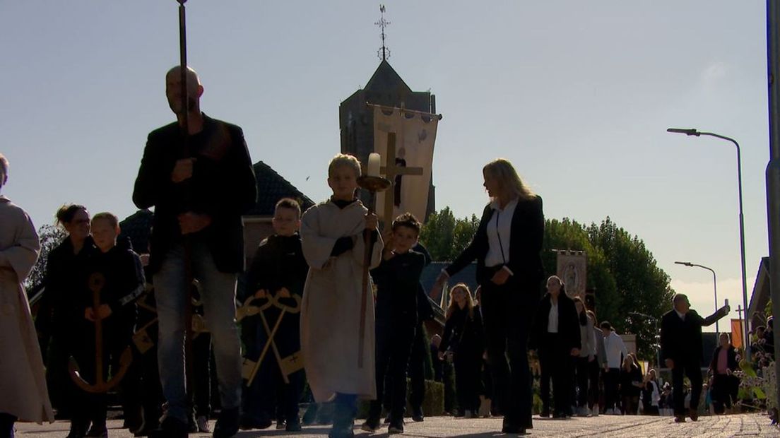 Jong en oud loopt mee tijdens de processie in Azewijn.