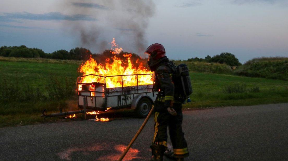 De brandweer blust de brandende aanhanger
