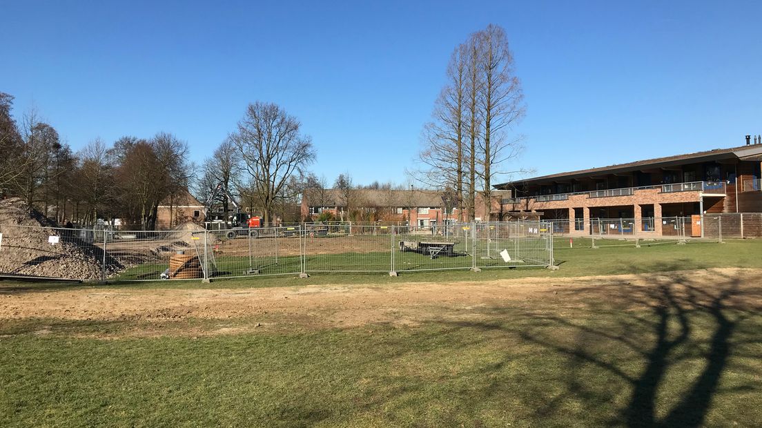 De bouw is begonnen, rechts een van de scholen. Op het grasveld op de voorgrond komt het tweede gebouw.