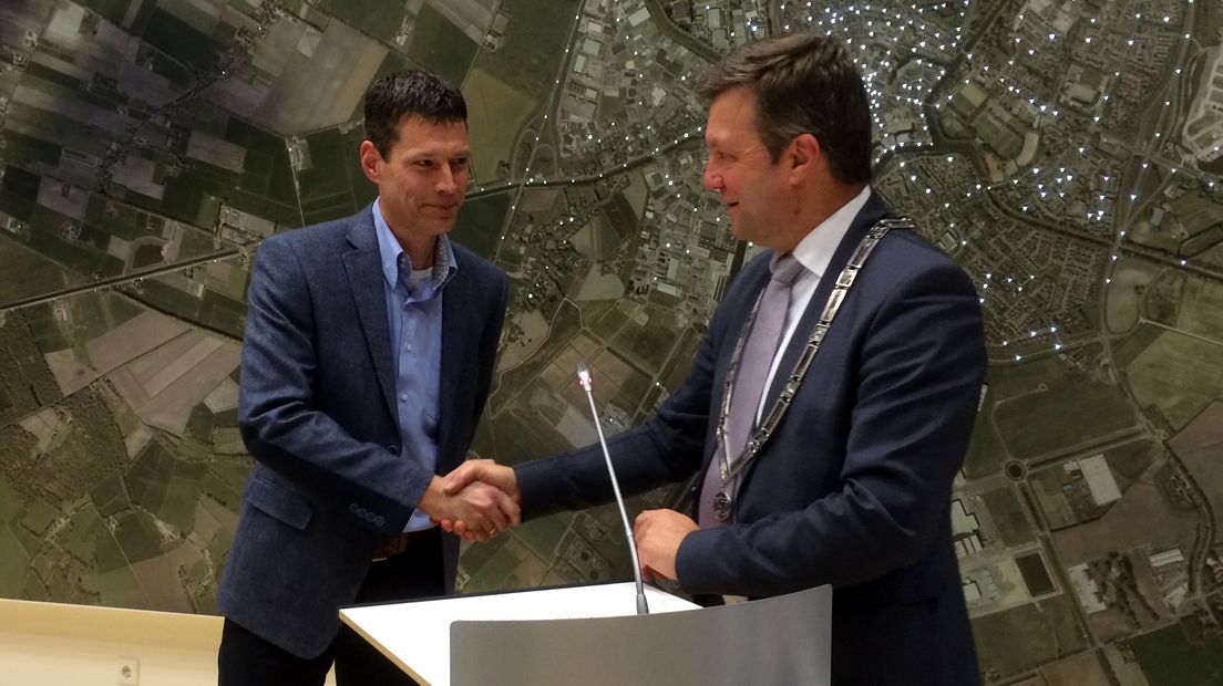 Burgemeester Bert Bouwmeester feliciteert het nieuwe raadslid Erik Holties