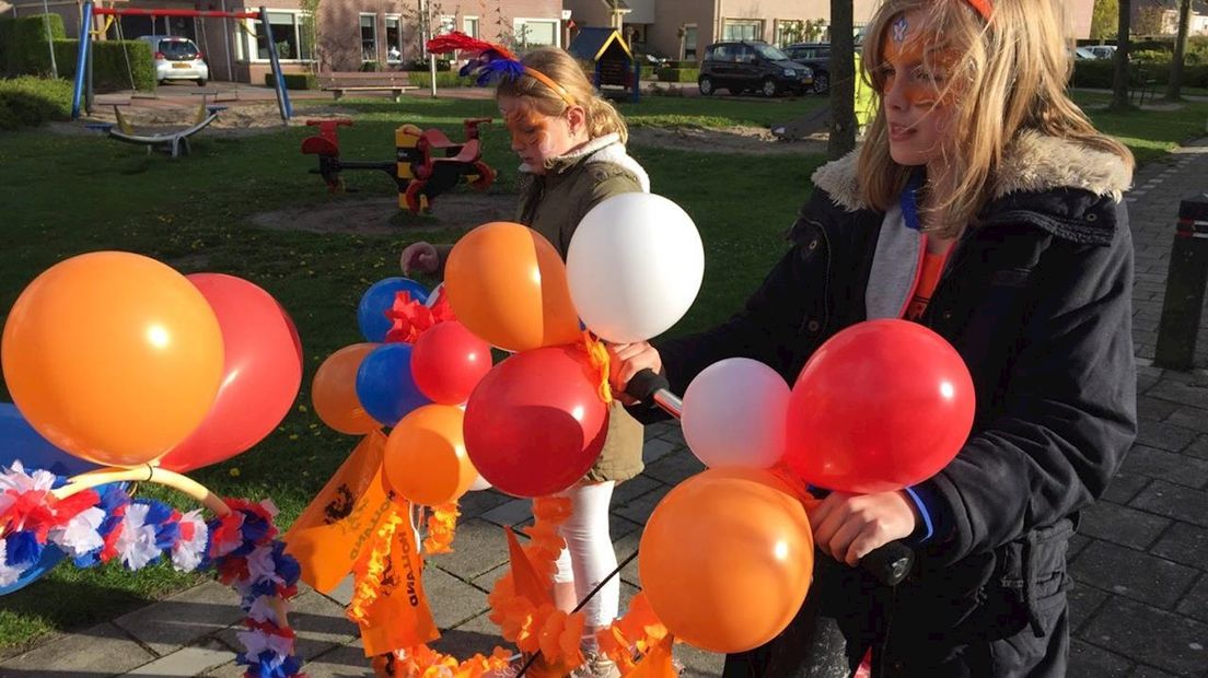 kinderen in IJsselmuiden rijden met skelters en versierde fietsen door de wijk Zeegraven