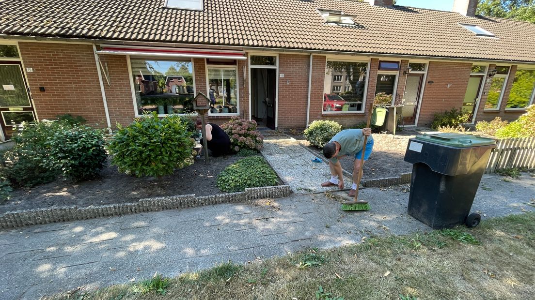 Harnold Scheepstra (rechts) werkt in de tuin van de familie Prins in Wildervank
