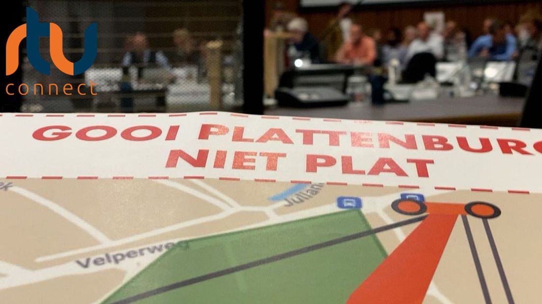 Huizenbezitters met protestborden 'Gooi Plattenburg Niet Plat' in de raadszaal op het Arnhemse stadhuis.