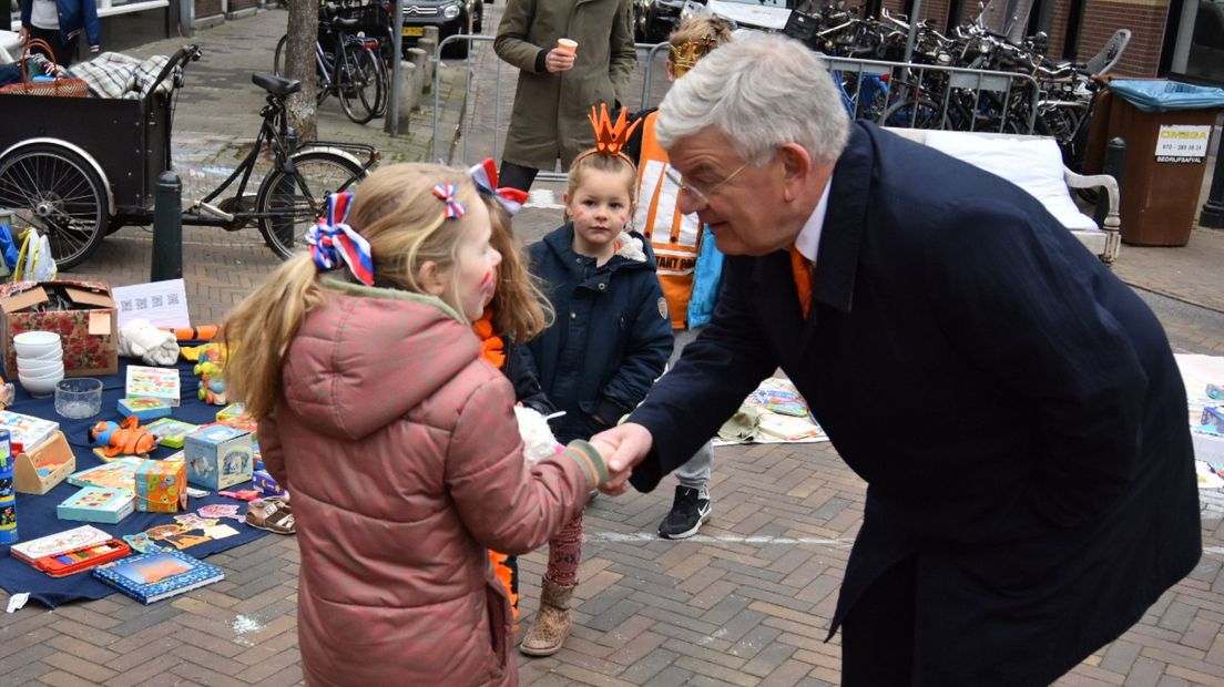 Burgemeester Van Zanen schut de hand van een van de verkopende kinderen