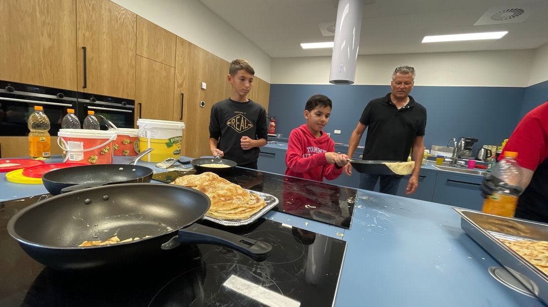 Kinderen bakken pannenkoeken in de keuken van de school