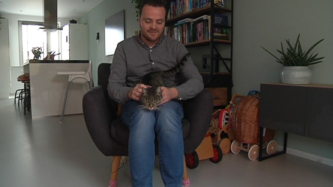 Jelmer Bergsma, de initiatiefnemer van het kattencafé, met een kat op zijn schoot.
