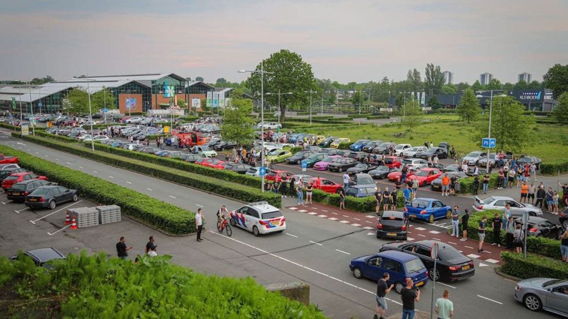 Op de parkeerplaats hebben zich veel mensen verzameld.