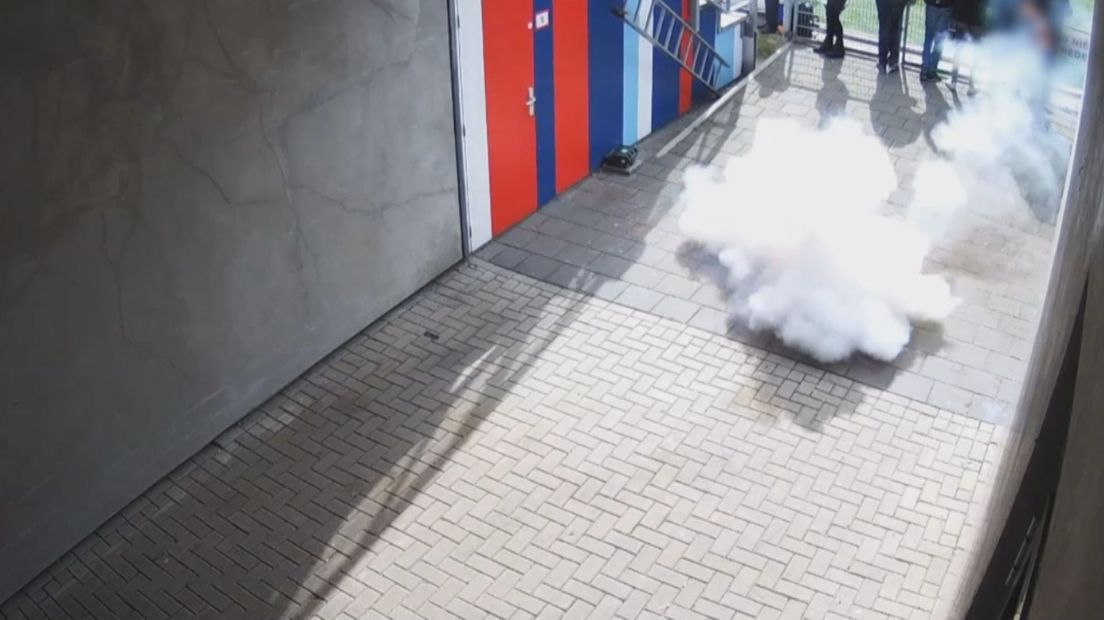 Vuurwerk dat vanaf de tribune is gegooid ontploft vlakbij publiek dat aan het veld staat te kijken