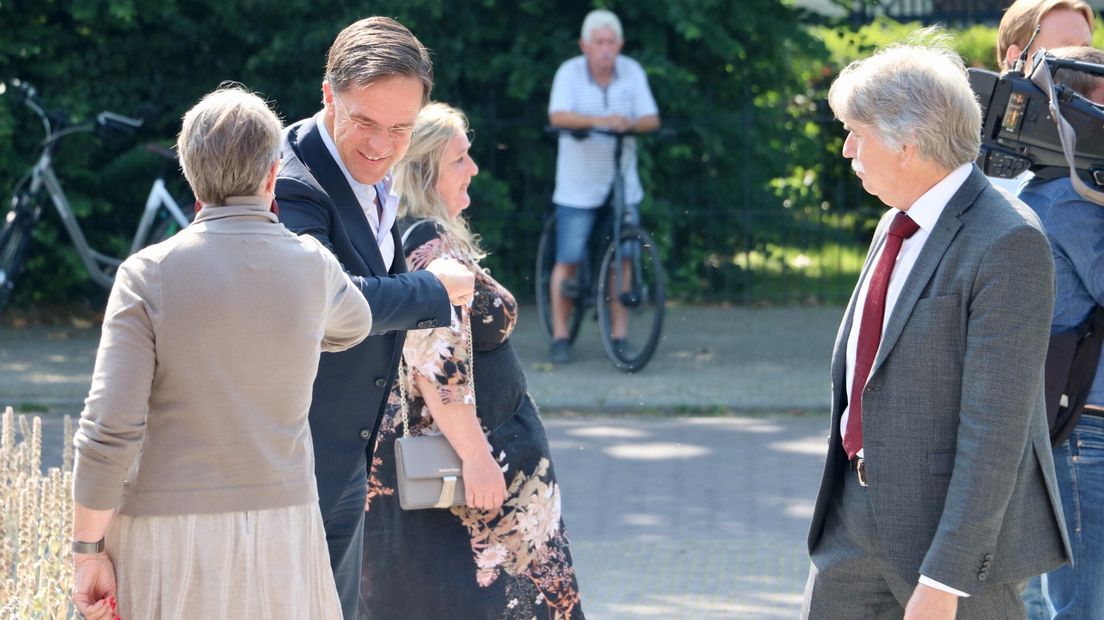 Premier Rutte wordt in Loppersum verwelkomd door onder anderen burgemeester Beukema (rechts)