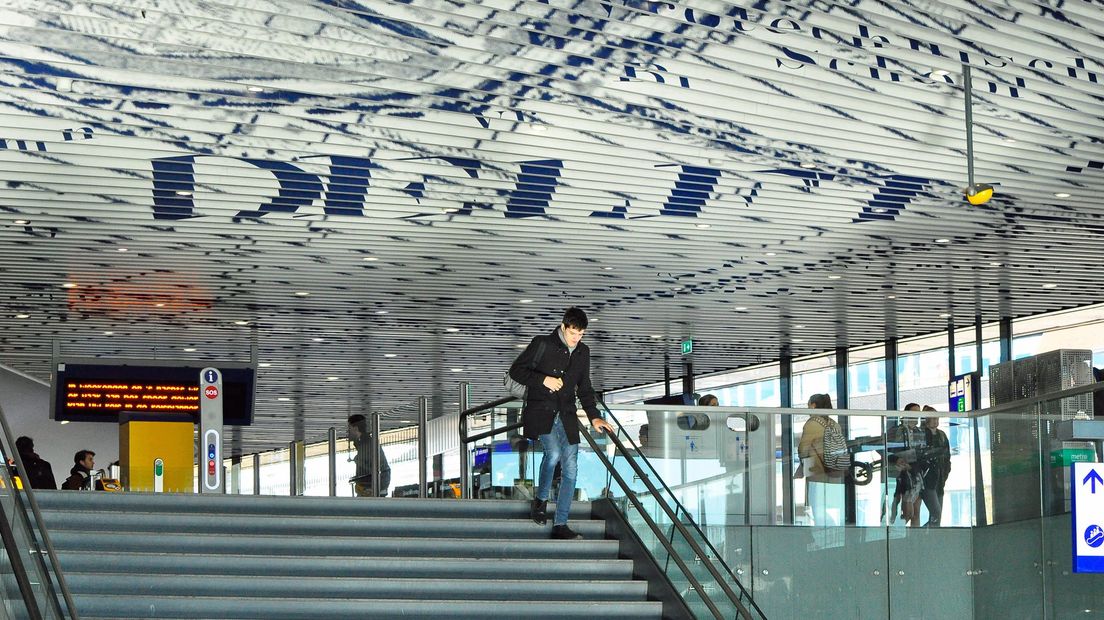 Reizigers in de stationshal van station Delft 