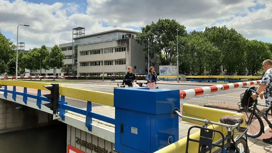 Fietsers gaan onder slagbomen kapotte Zuiderbrug door.