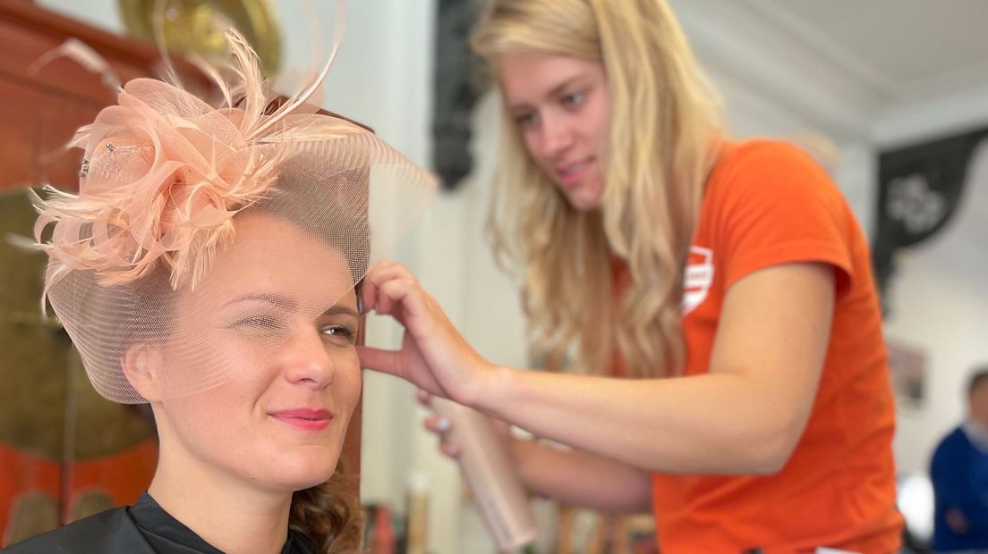 Anne Kuik (CDA) heeft een zalmroze jurk aan met bijpassend hoedje