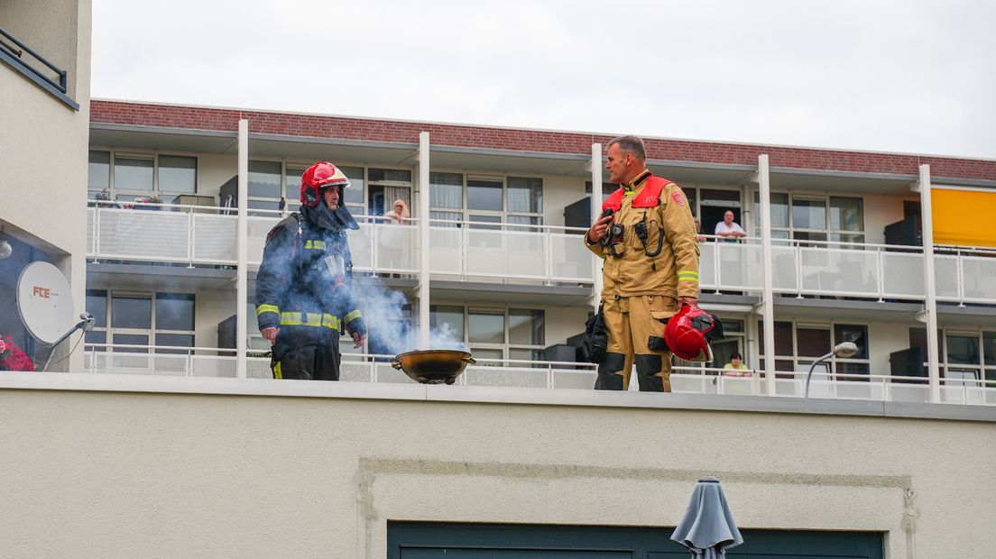 Brandweermensen bij den brandende barbecue in Stad