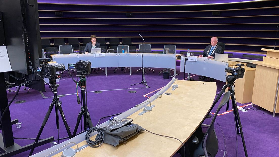 Vanuit een bijna lege raadszaal zit burgemeester Frans Backhuijs de vergadering voor
