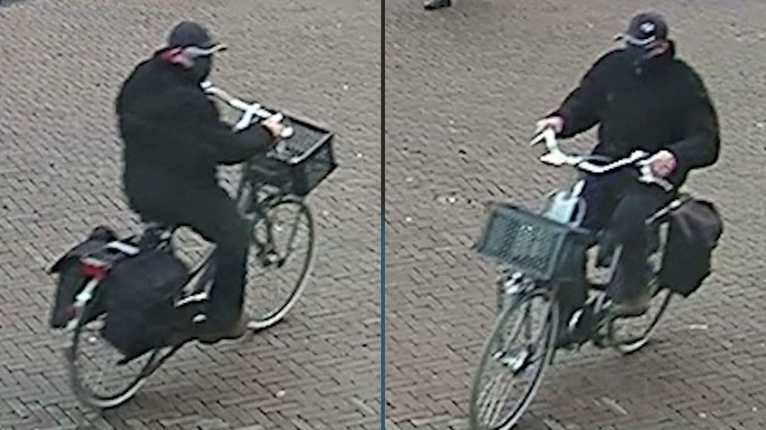 De man reed op een zwarte damesfiets met een donkere krat voorop, achterop zaten twee zwarte fietstassen.