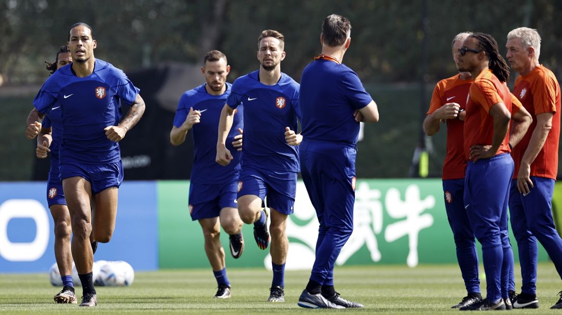 Spelers van het Nederlandse elftal tijdens de training, de staf kijkt toe
