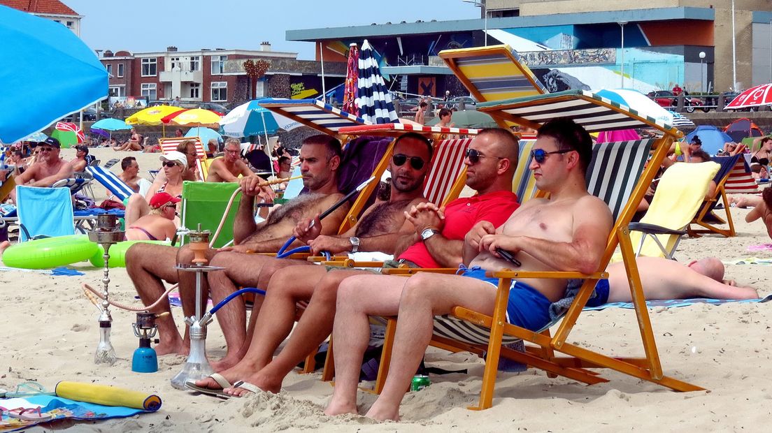 Mannen genieten van het weer op het strand in Vlissingen