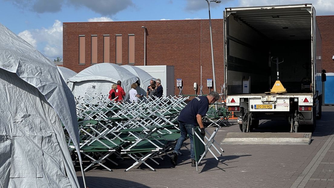 Medewerkers van het Rode Kruis ruimen de tenten op