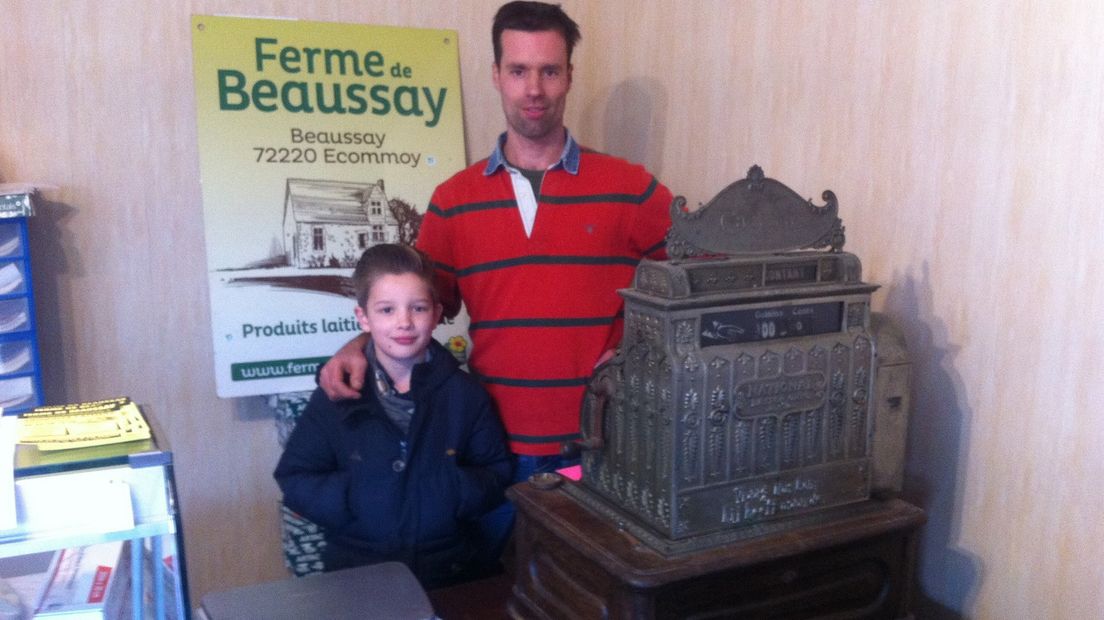 Philip Smid met zijn zoontje bij de antieke kassa die de winkel van zijn vader zo kenmerkte.