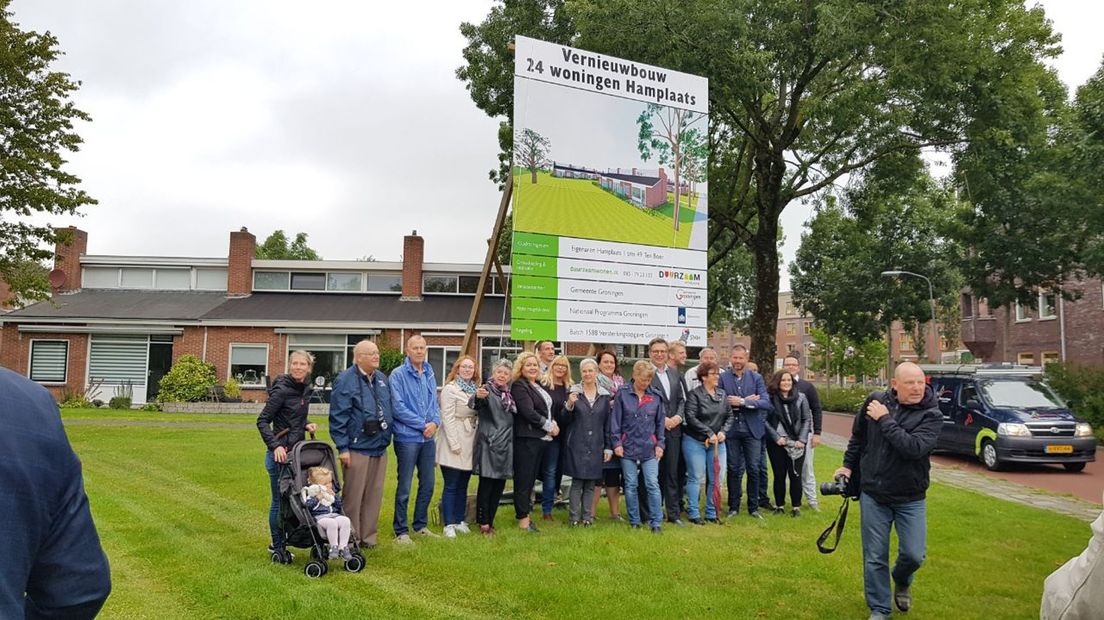Bewoners van de Hamplaats en genodigden bij het bord dat is geplaatst