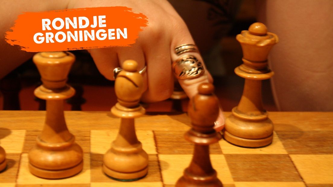 Iemand doet een zet met de dame in het schaakspel