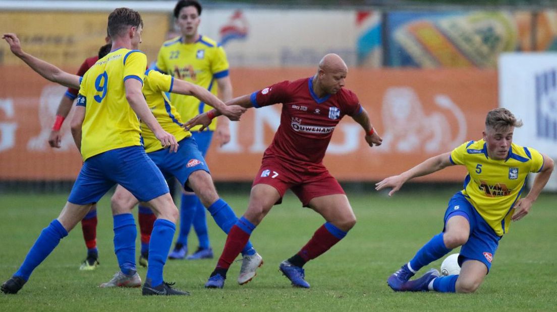 Quick Boys-speler Kay Tejan wordt omcirkeld door spelers van OSS 1920