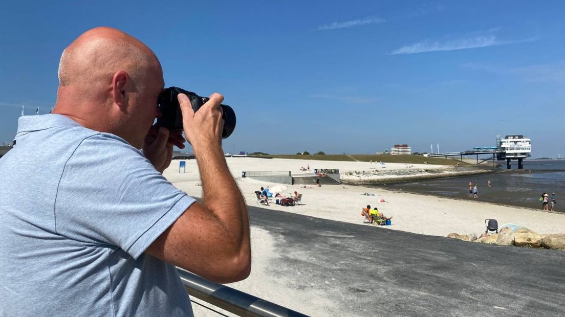 Tonny de Vries zet de kustlijn bij het strand van Delfzijl op de foto