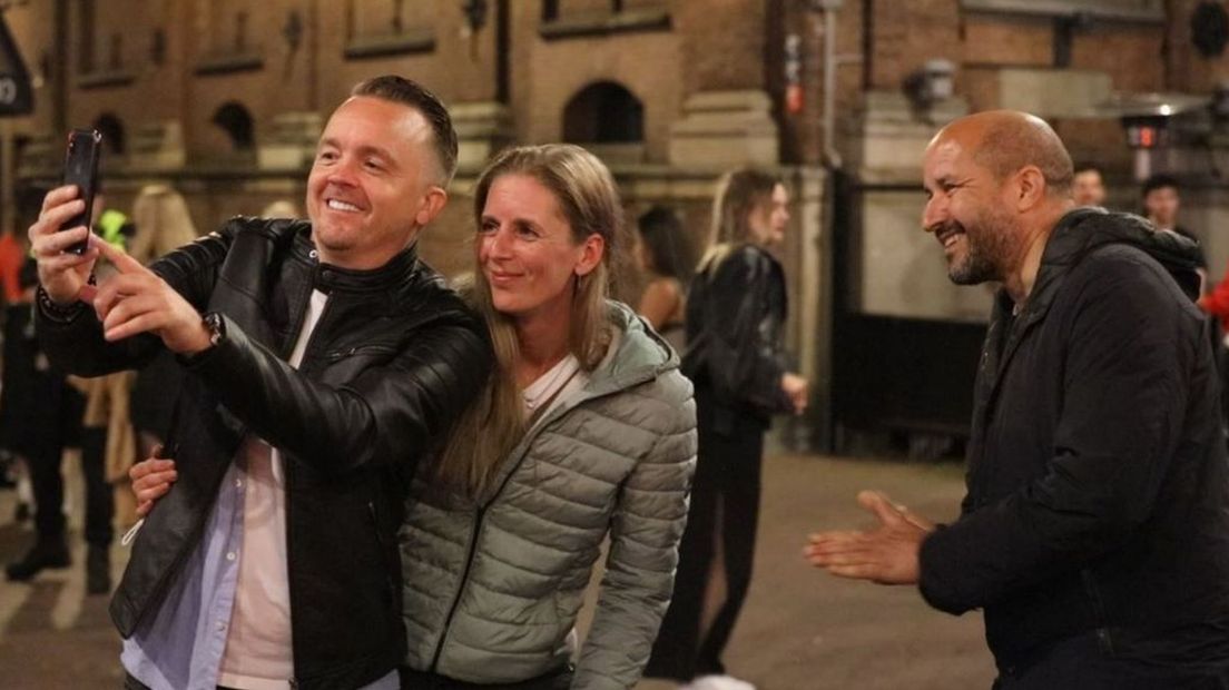 Een man en een vrouw nemen een selfie met burgermeester Marcouch.
