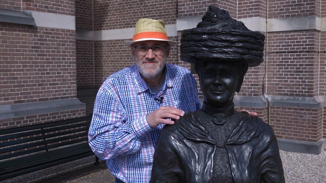 Is ze net ter kerke geweest? Die dame die daar staat in het brons. Met haar grote hoed op en haar paraplu of is het toch een parasol in haar hand. Wellicht maakt ze zomaar een ommetje door koninklijk Apeldoorn. De jonge koningin Wilhelmina.