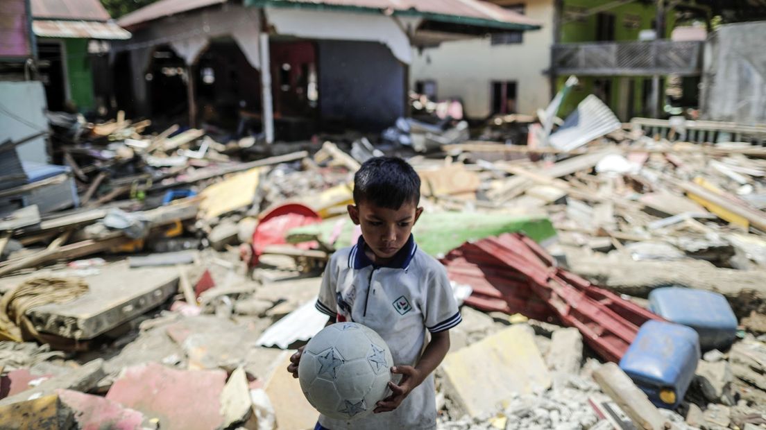 Een jongetje heeft in ieder geval nog zijn voetbal na de aardbeving in Sulawesi