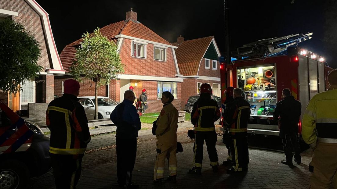 Brandweerlieden kijken toe nadat het vuur is geblust van de woningbrand in Nieuwe Pekela