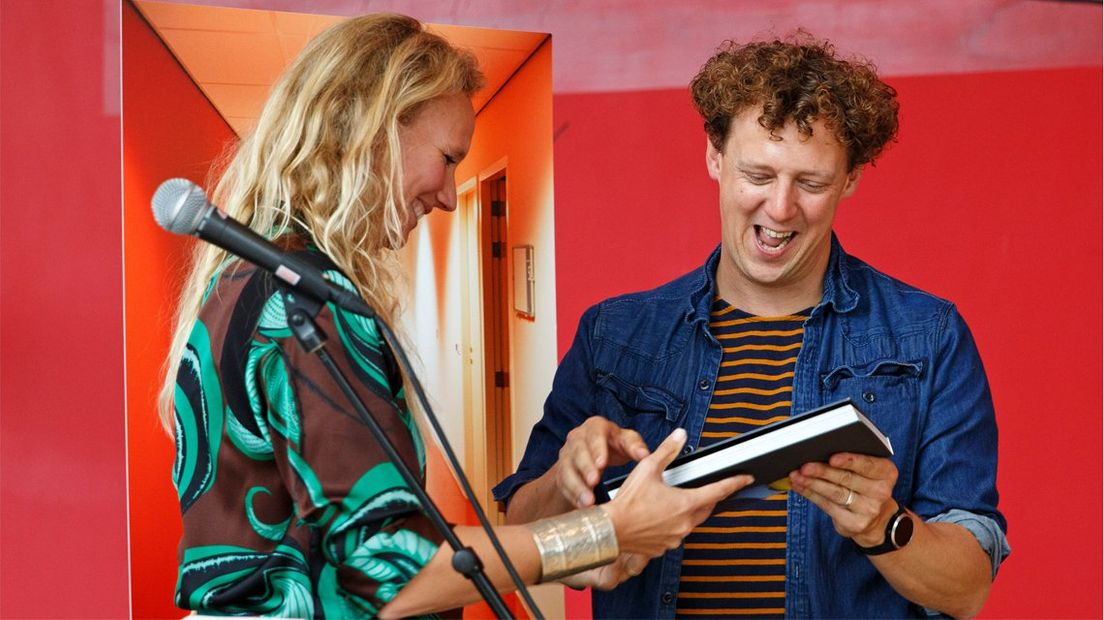 Anne Reitsma overhandigt het fotoboek JocheM aan Jochem Myjer. 
