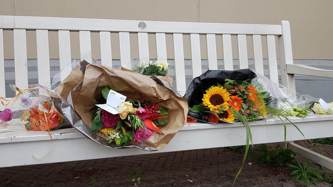 Bloemen voor Prinsen Christina op een bankje voor de paleistuinen in Den Haag
