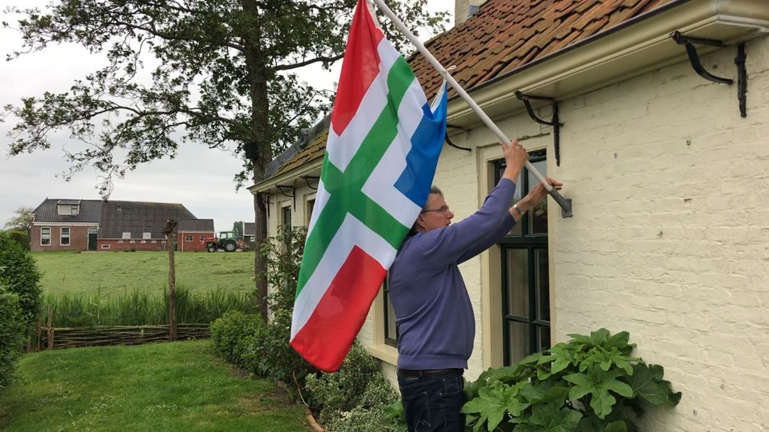 Een inwoner van Westerwijtwerd hangt een Groningse vlag