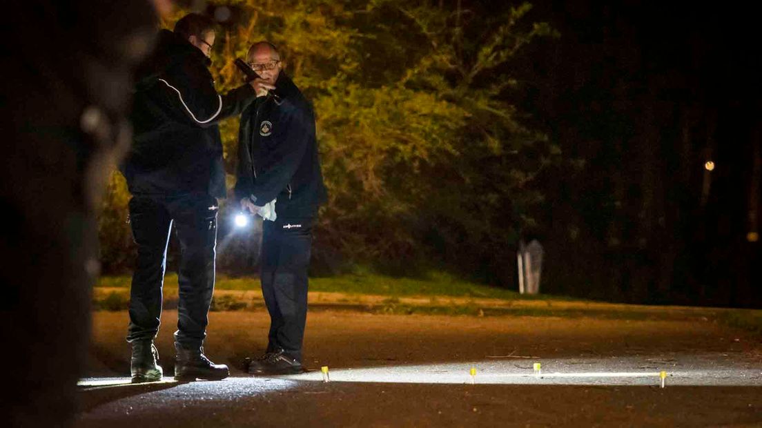 Agenten bij de gevonden kogelhulzen.