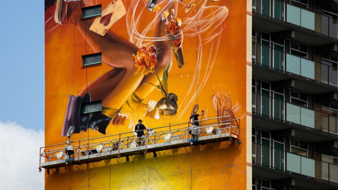 Het kunstenaarsduo Studio Giftig werkt op grote hoogte aan de muurschildering van DI-RECT