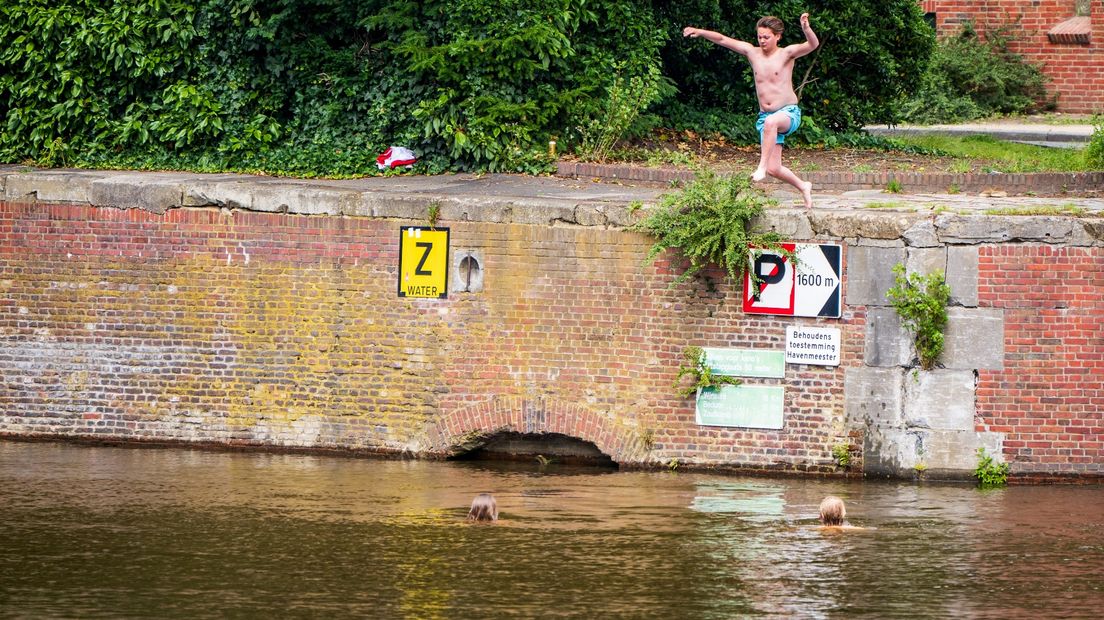 Een student springt in de stad Groningen in het water