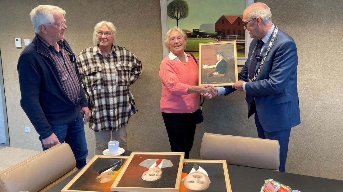 Burgemeester Adriaan Hoogendoorn (rechts) neemt de schilderijen in ontvangst